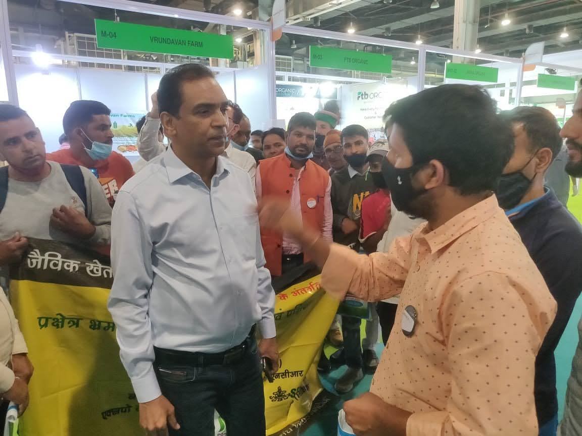 Conversation at a trade exhibition stand with visitors around.