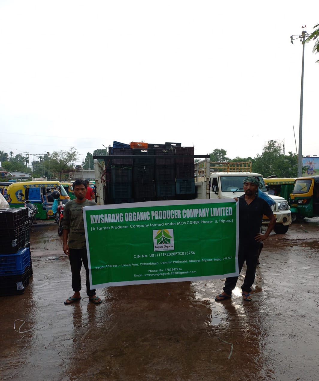 Crates of produce loaded for transport beside a Farmer Producer Company banner.
