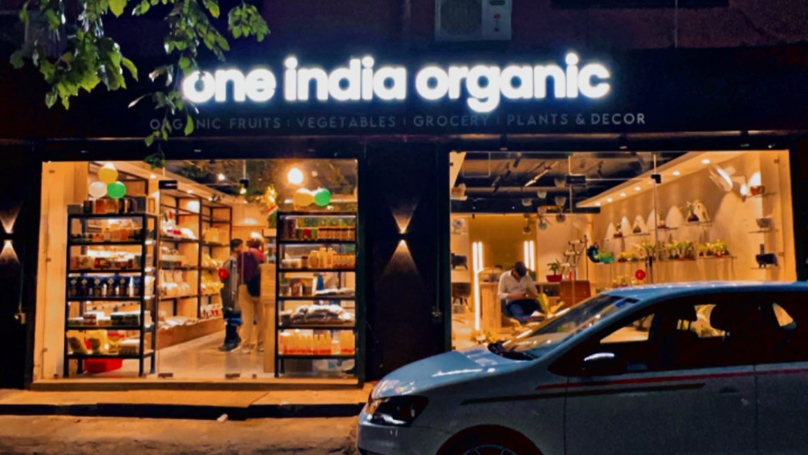 One India Organic retail storefront lit at night.